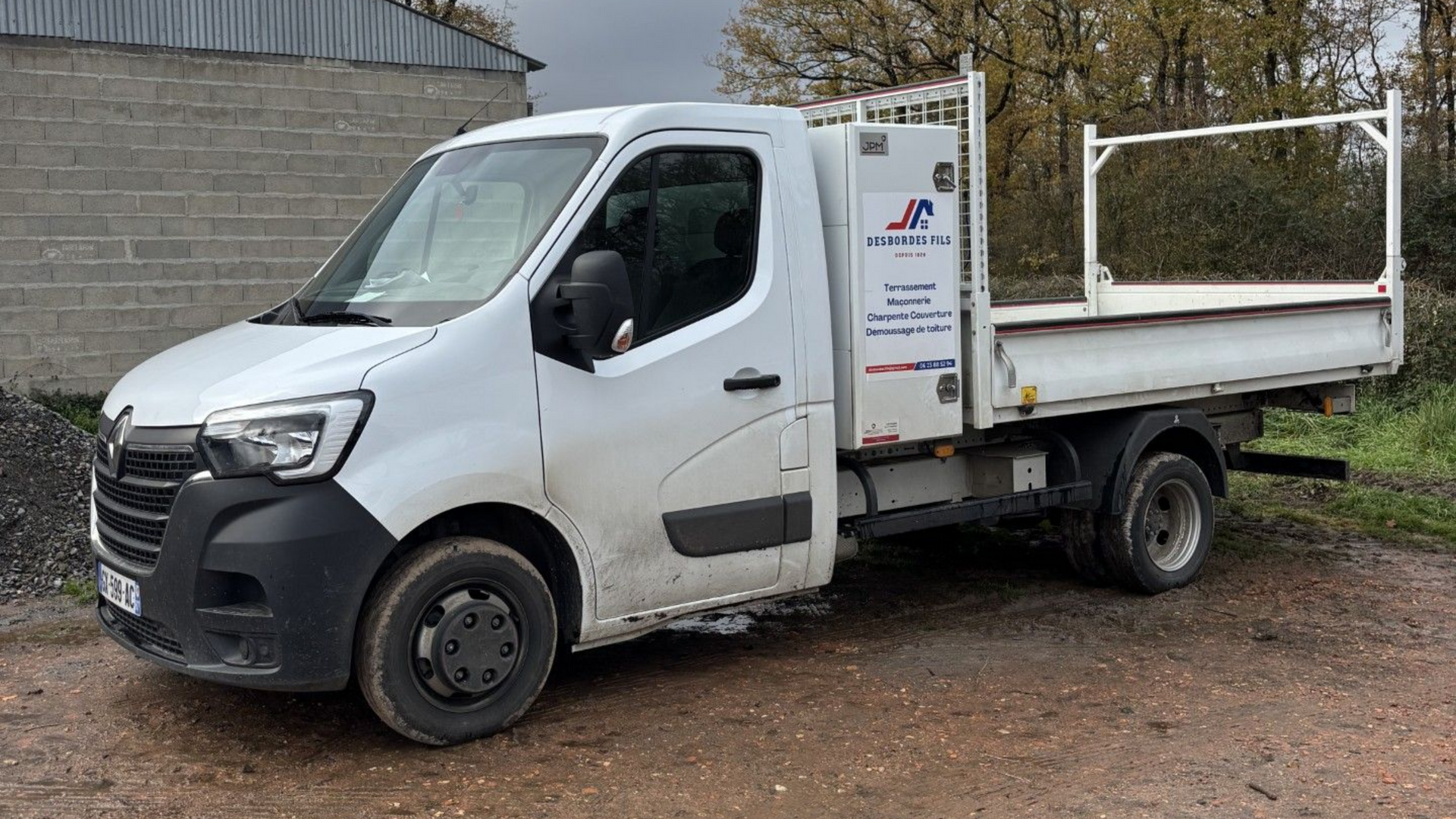 Camion à plateau blanc stationné à l'extérieur.