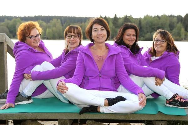 Physiotherapie Brit Hermersdorfer Praxisteam sitzt auf einer Yogamatte auf einem Steg