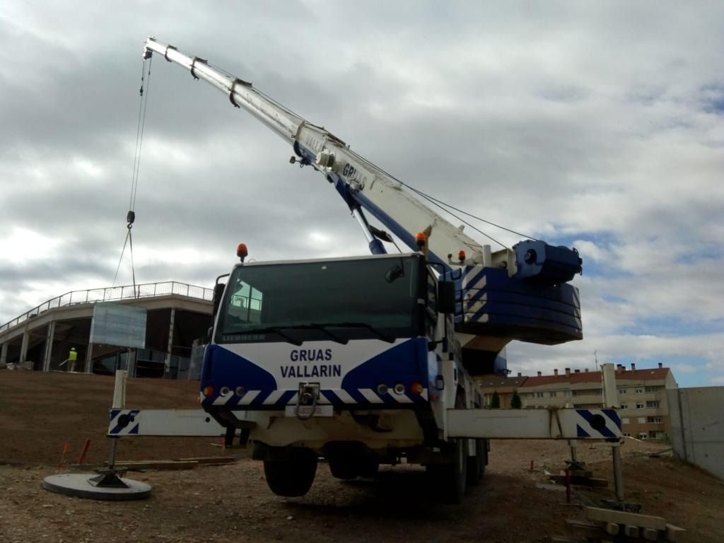 Un camión azul y blanco con una grúa en la parte trasera.