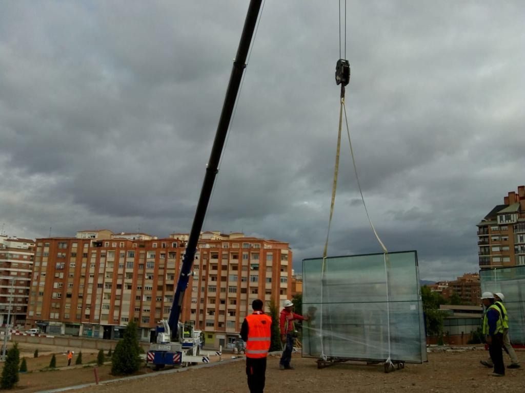 Un gran trozo de vidrio está siendo levantado por una grúa.