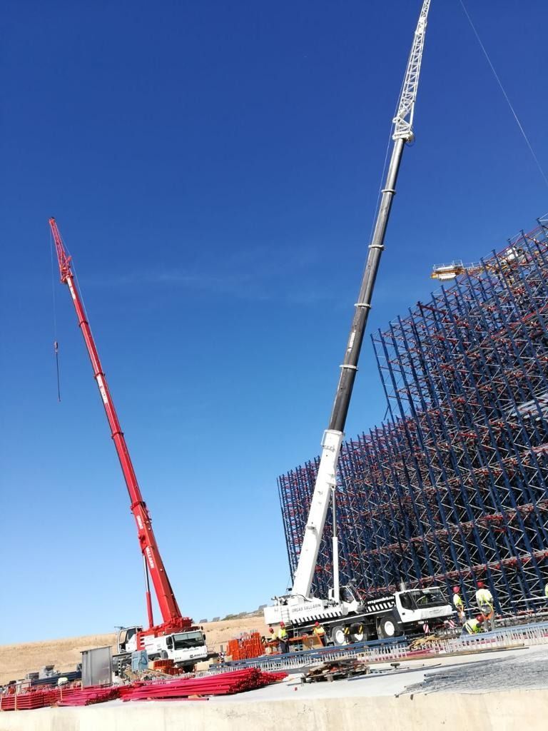 Una gran grúa se encuentra frente a un edificio en construcción.