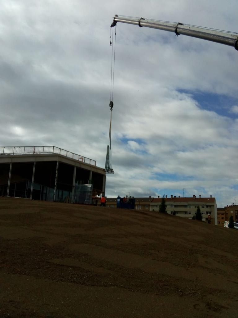 Se está utilizando una grúa grande para levantar un objeto grande.