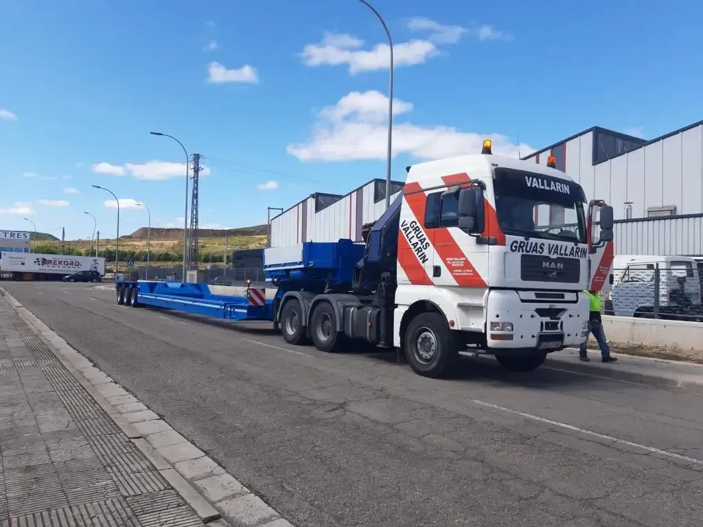 Un camión blanco y rojo está estacionado al costado de la carretera.