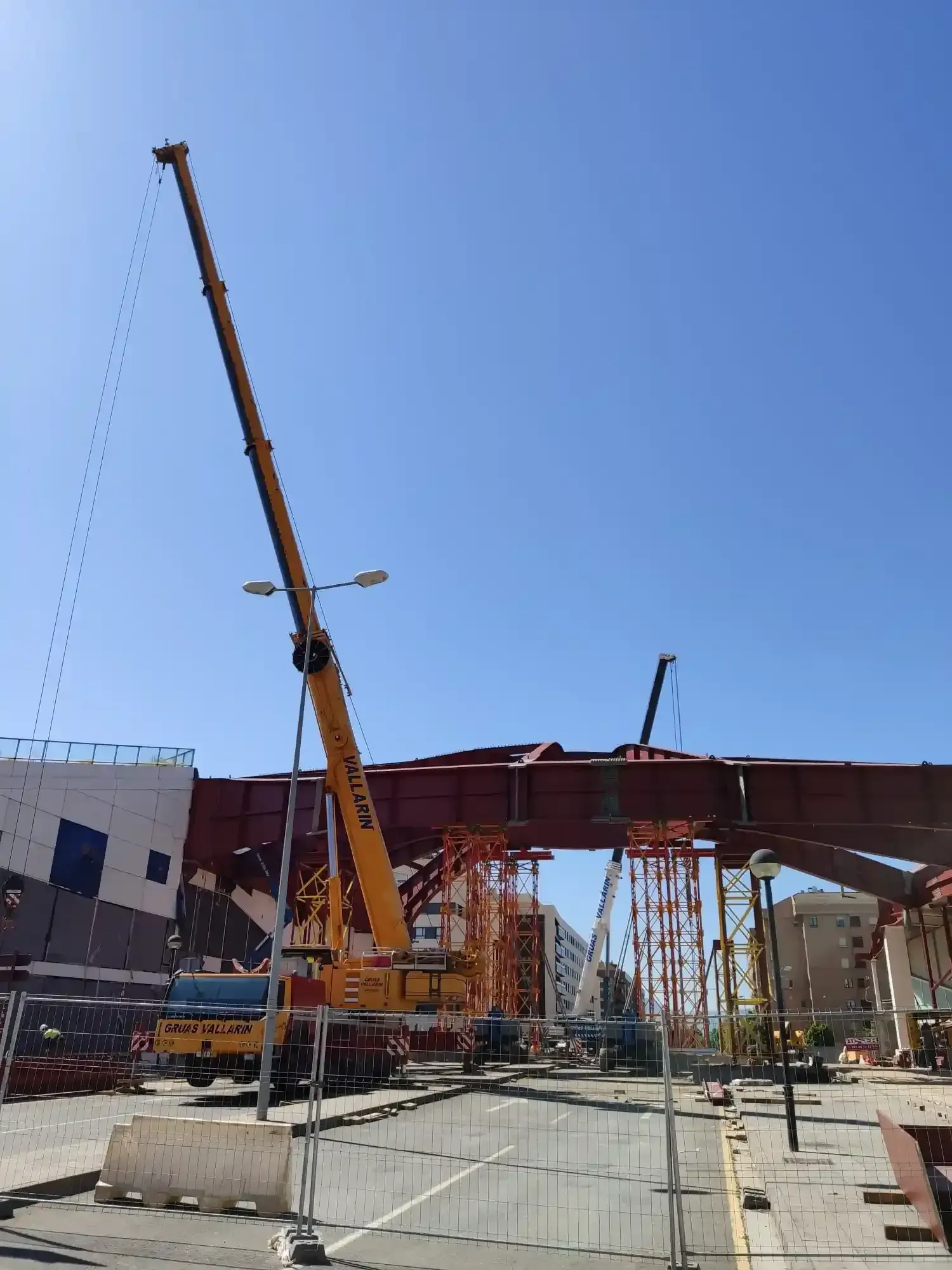 Una gran grúa amarilla está levantando una gran estructura metálica.