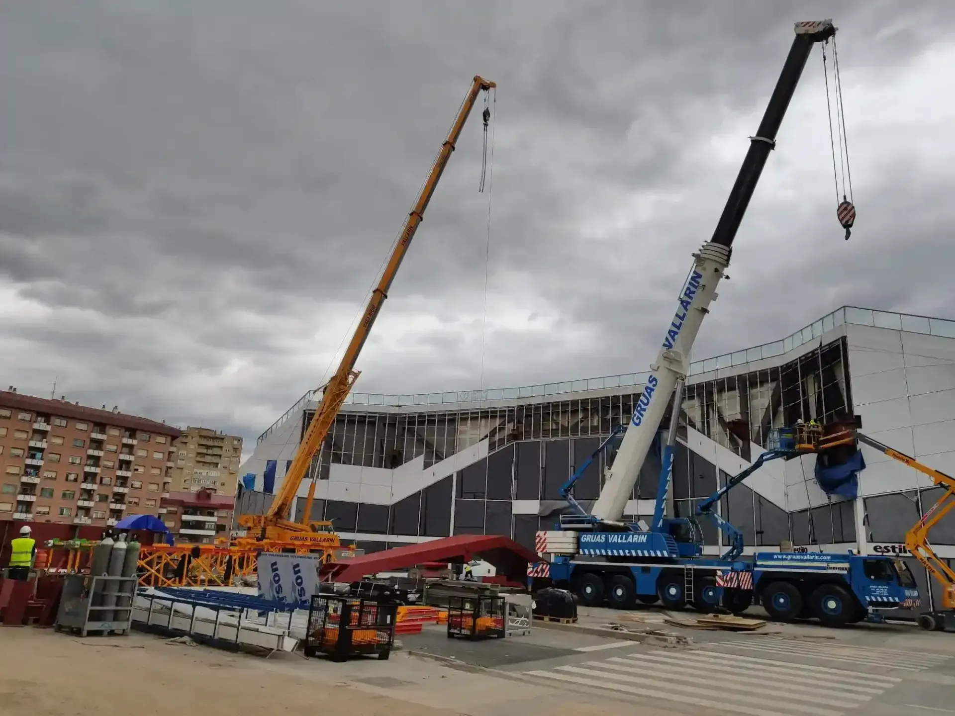 Una gran grúa está parada frente a un edificio en construcción.