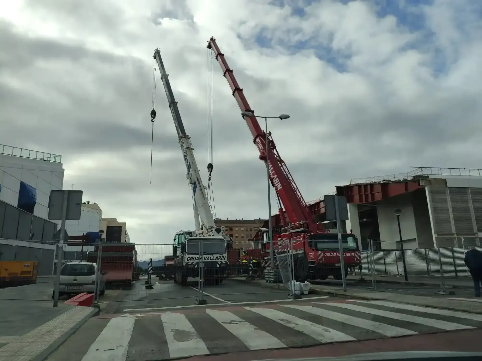 Una gran grúa roja está en medio de una calle.