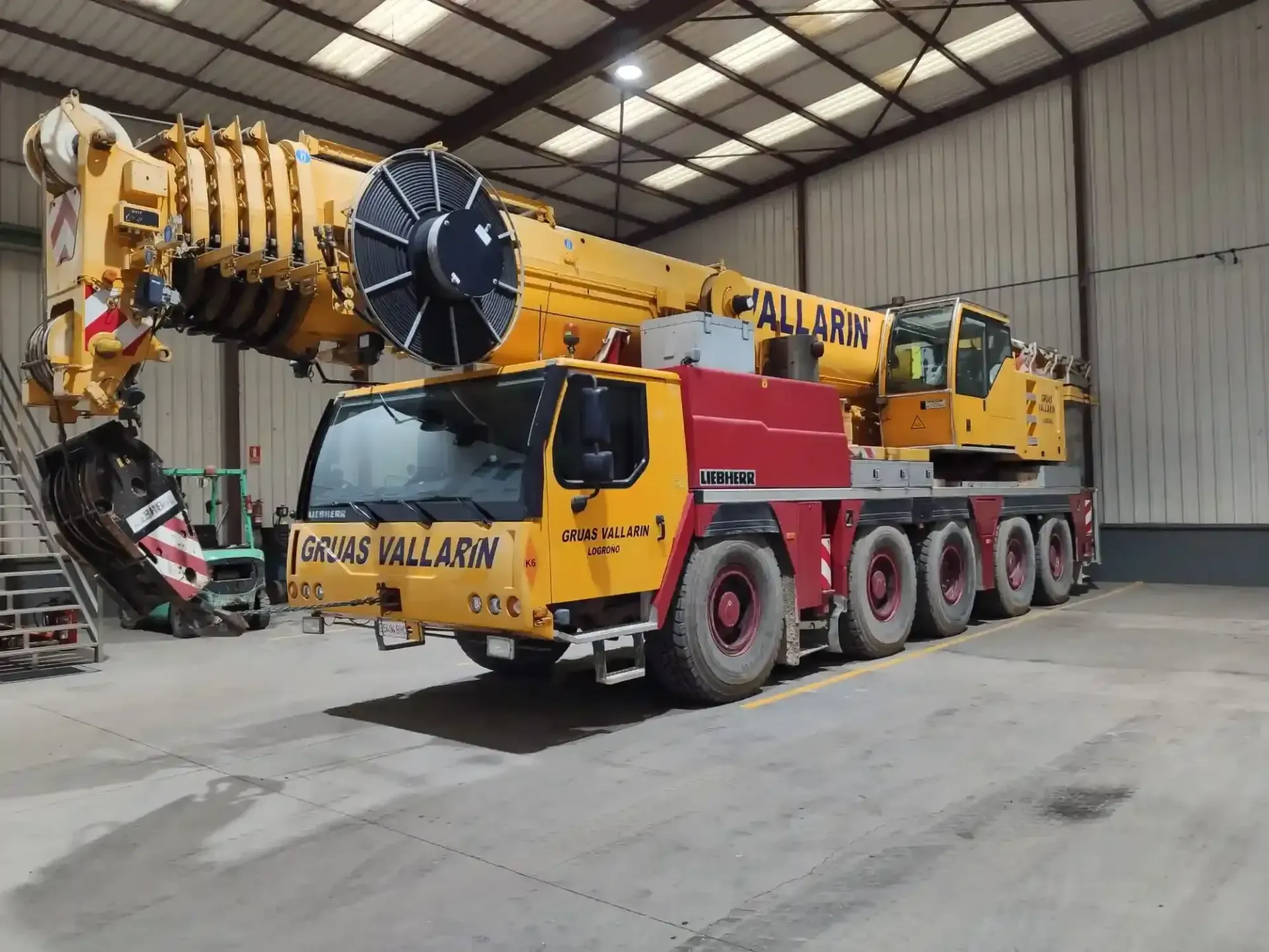 Una gran grúa amarilla está estacionada en un almacén.