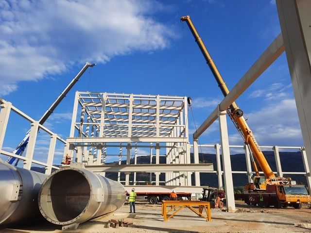Un gran edificio en construcción con una grúa en primer plano.