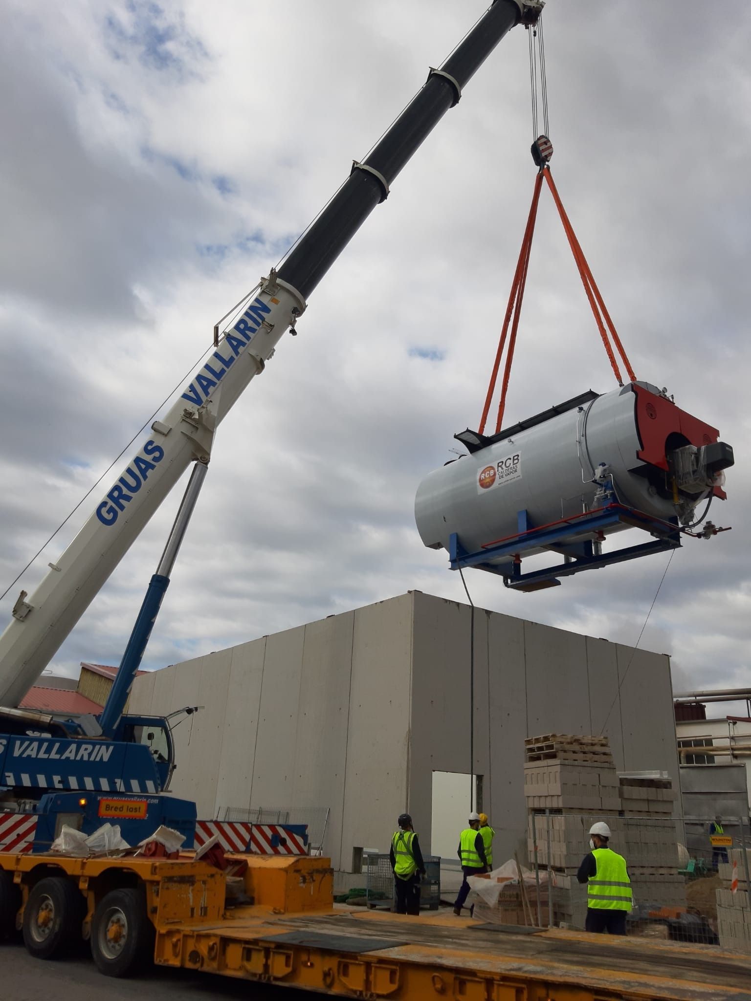 Una gran grúa está levantando un gran tanque en el aire