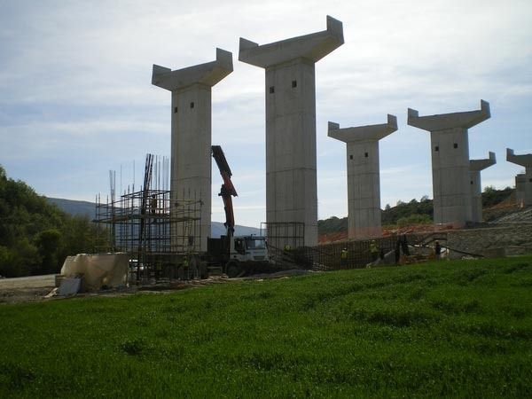 Una hilera de pilares de hormigón en un campo de hierba