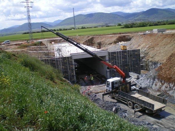 Una grúa está levantando un camión hacia un túnel en construcción.