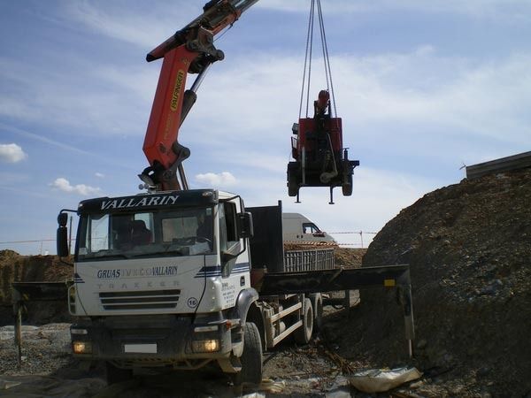 Un camión vallarey está siendo levantado por una grúa