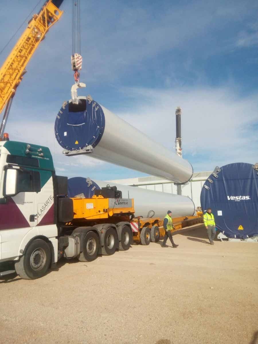 Un camión está siendo levantado por una grúa en un estacionamiento.