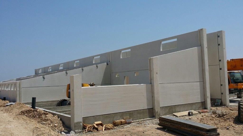 Se está construyendo un gran edificio en medio de un campo de tierra.