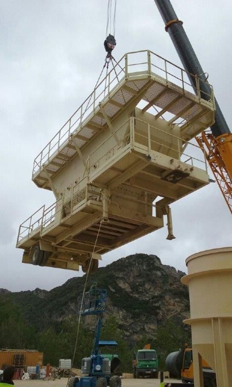 Una grúa levanta una pieza grande de equipo