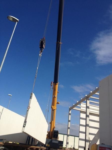 Una grúa está levantando un gran trozo de hormigón.