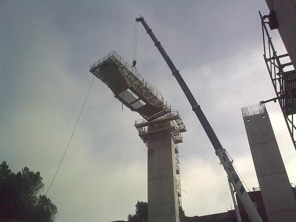 Una gran grúa está levantando un gran trozo de hormigón.