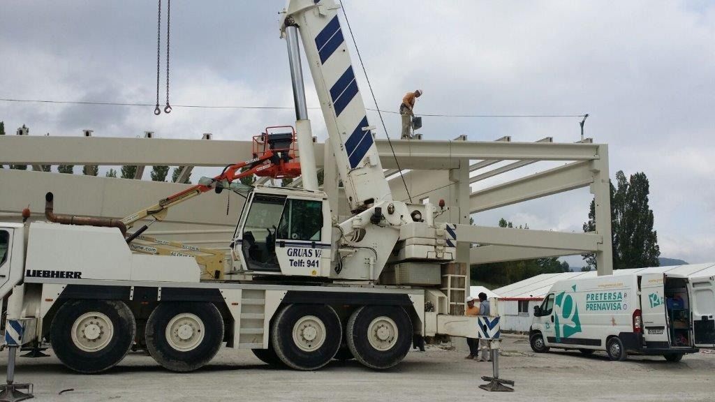 Una gran grúa blanca está estacionada en un estacionamiento