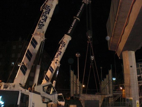 Dos camiones grúa del valle están levantando algo por la noche
