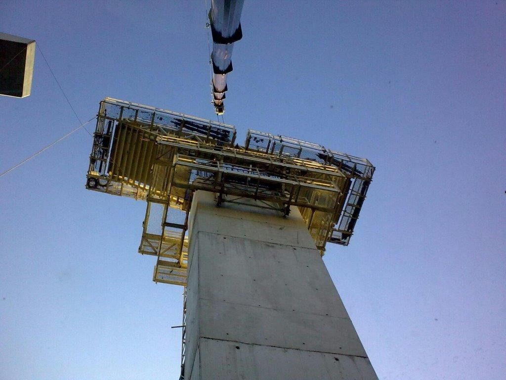 Una gran torre de hormigón con una grúa acoplada.