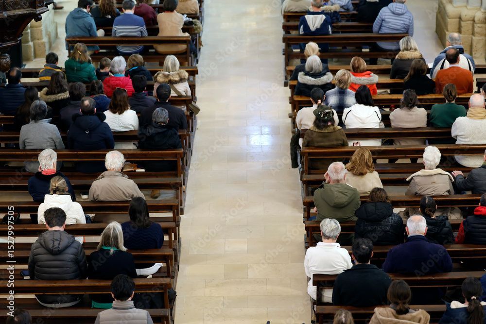 Menschen sitzen in Reihen auf hölzernen Kirchenbänken.