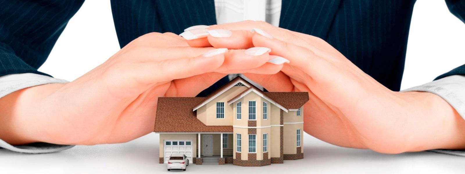 Manos ahuecando una casa modelo, simbolizando protección.