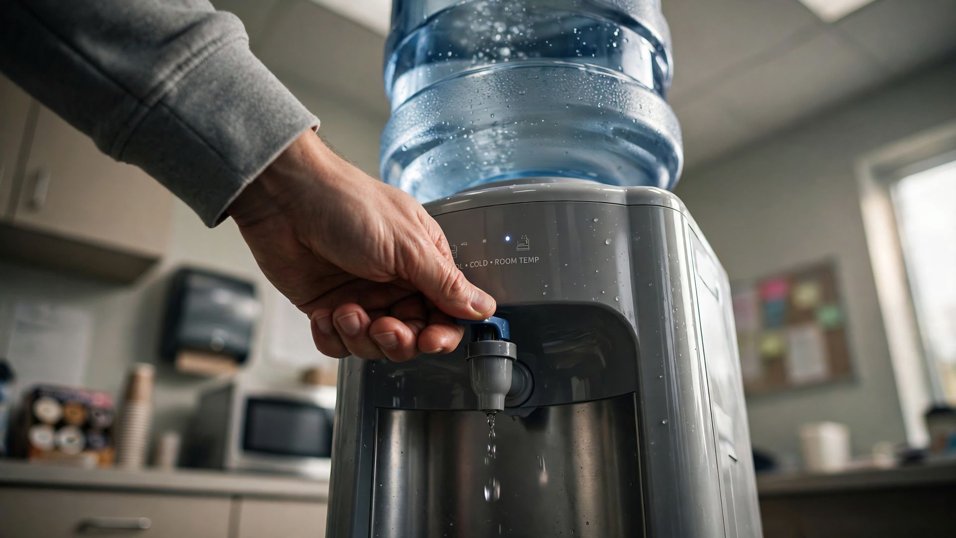 Une main utilise un distributeur d’eau