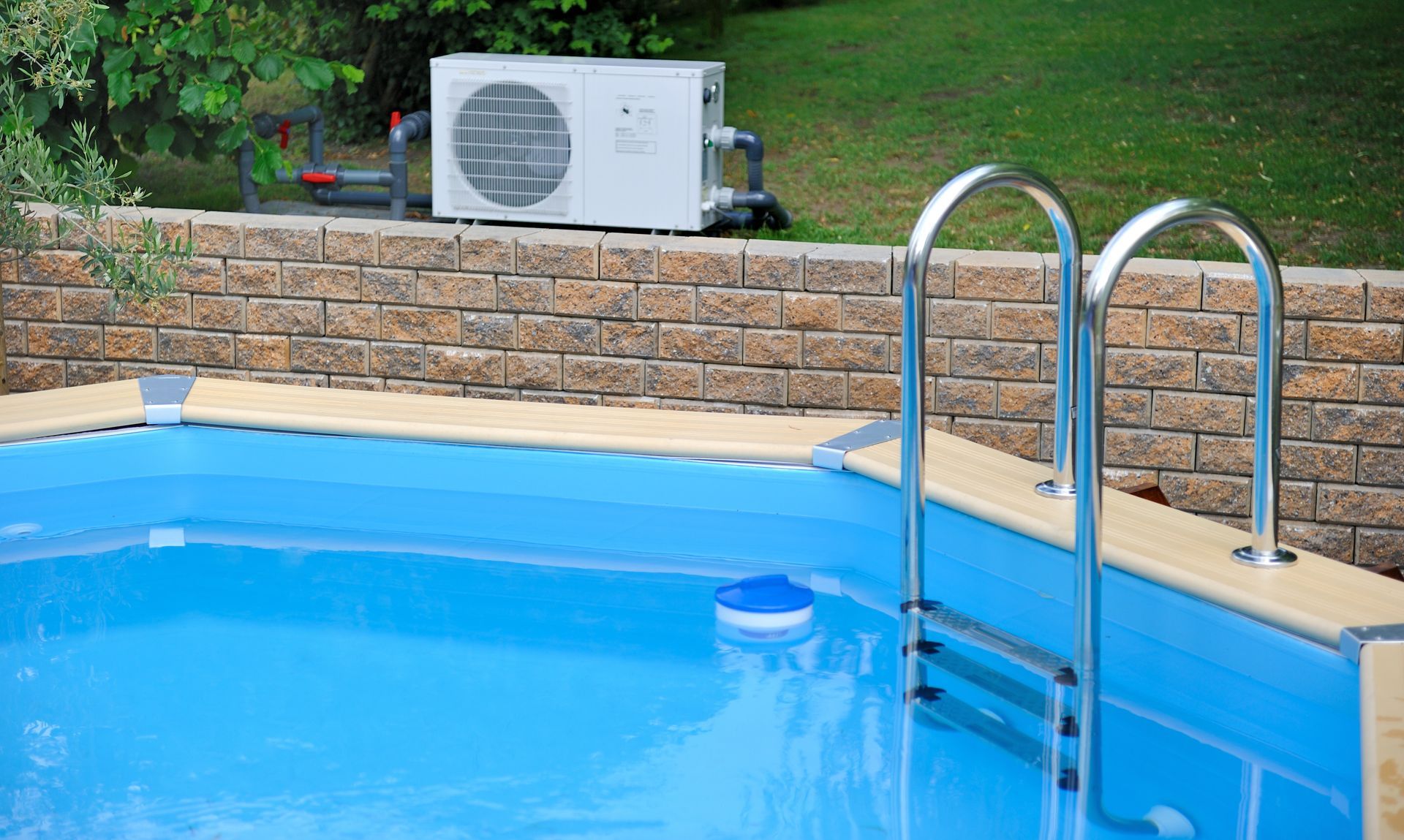 Piscine avec une échelle et une pompe à chaleur en arrière-plan