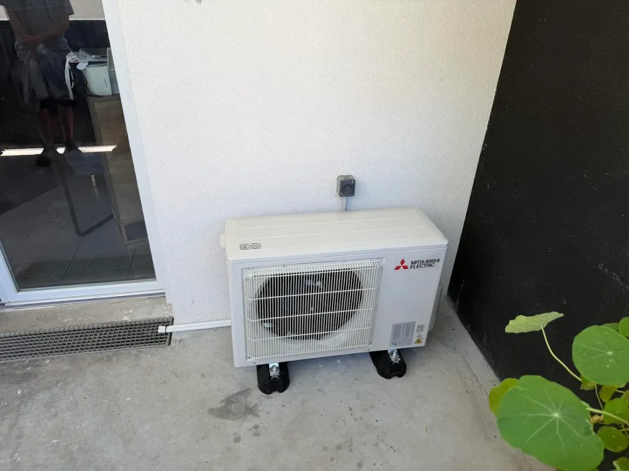 Unité extérieure de climatisation blanche sur une terrasse