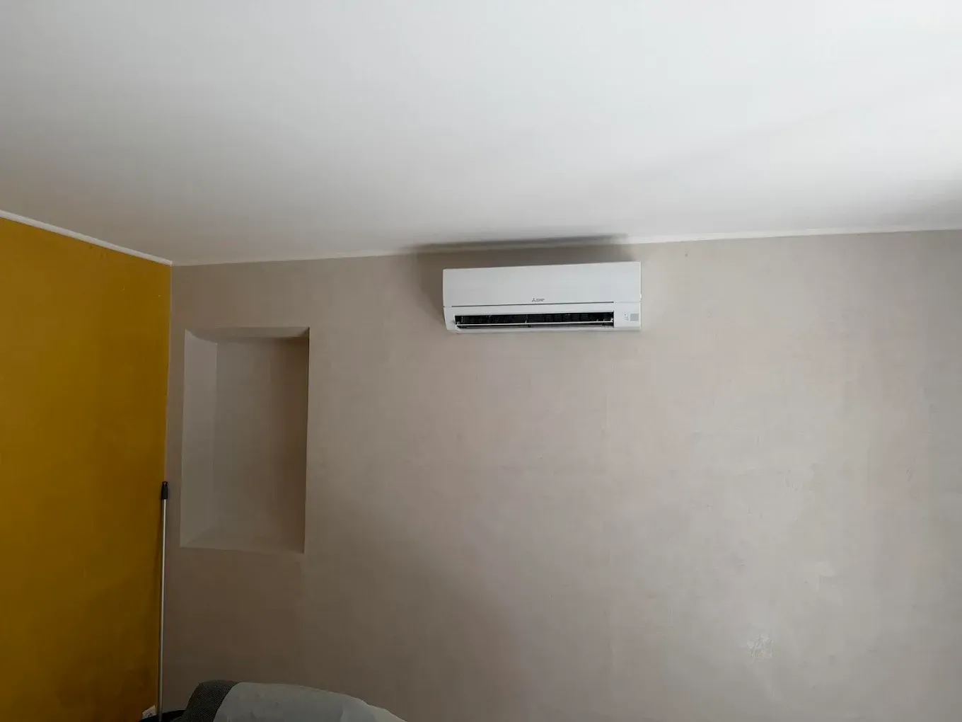 Pièce avec un mur jaune et un climatiseur mural