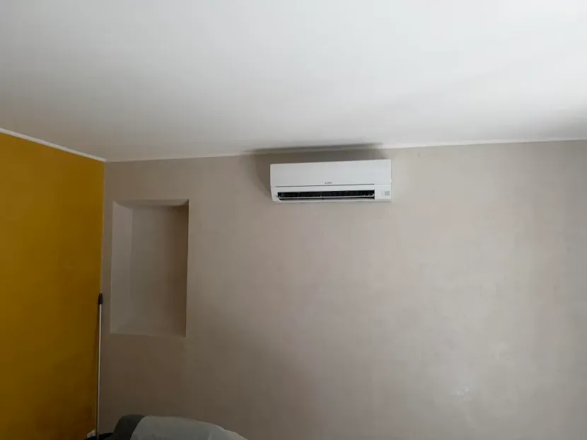 Pièce avec un mur jaune et un climatiseur mural