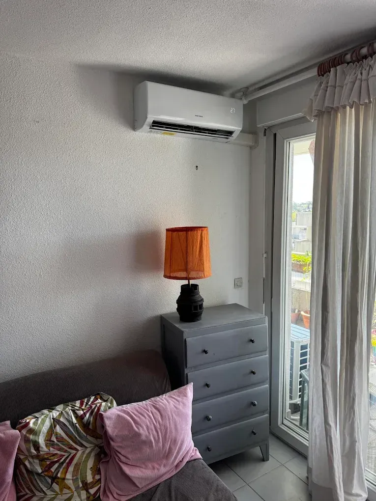 Petit coin de chambre avec une climatisation murale