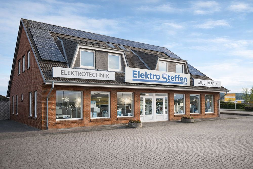 Vor einem Gebäude mit der Aufschrift „Hans Steffen“ steht ein Lieferwagen