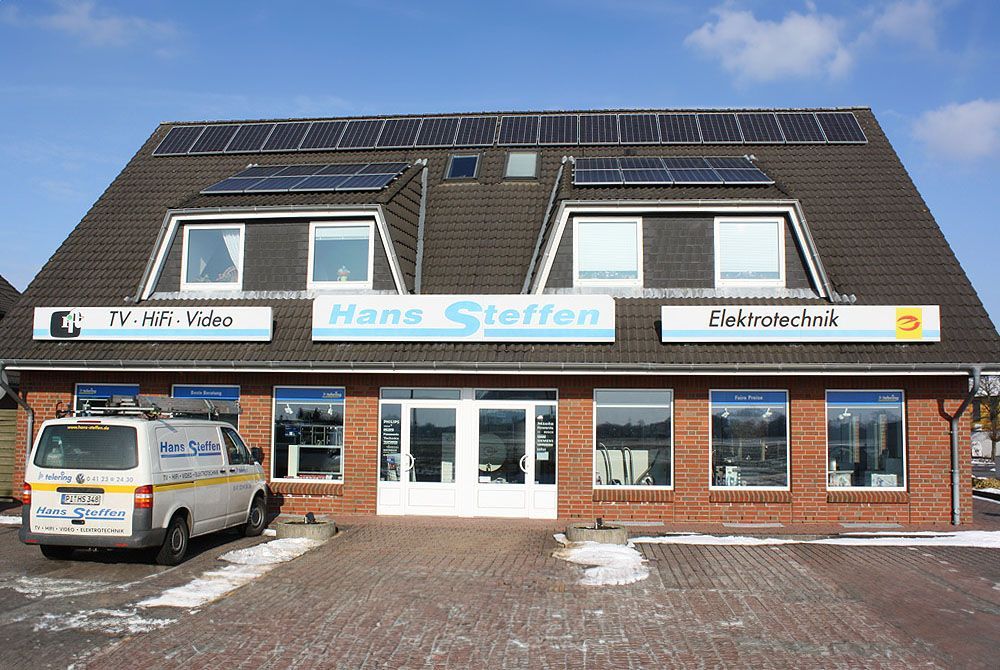 Vor einem Gebäude mit der Aufschrift „Hans Steffen“ steht ein Lieferwagen