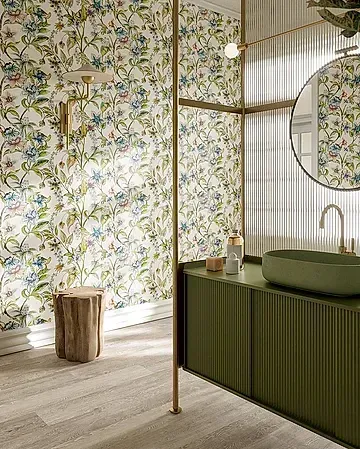 Un baño con lavabo, espejo y papel pintado floral.