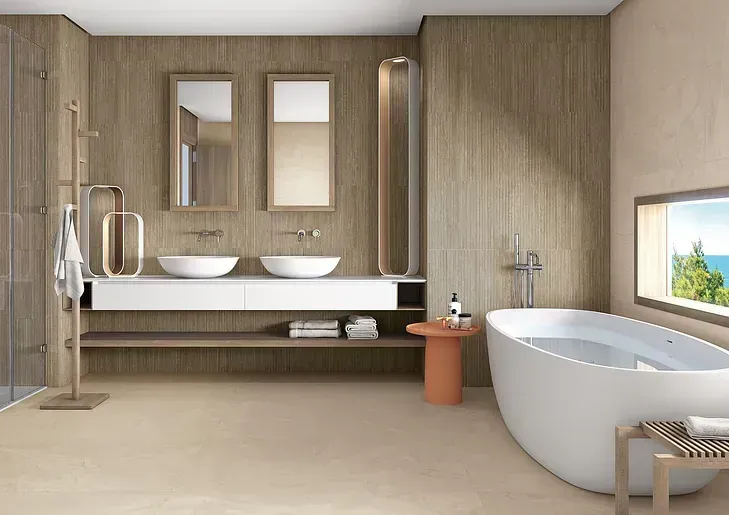 Un baño con bañera, lavabos, espejos y ventana.