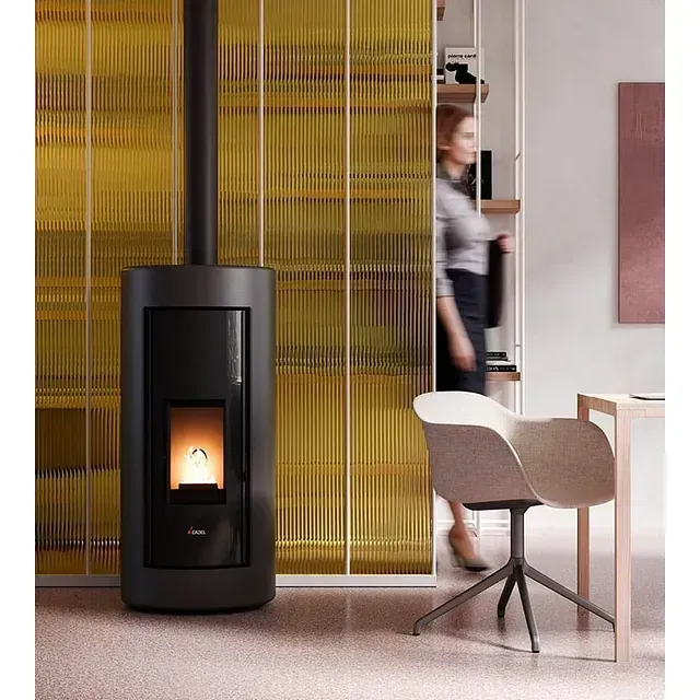 Una mujer está de pie en una habitación junto a una estufa.