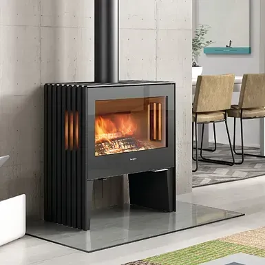 Una estufa de leña está ubicada en una sala de estar al lado de una mesa y sillas.