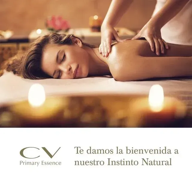 Una mujer está acostada en una cama recibiendo un masaje de CV Primary Essence.