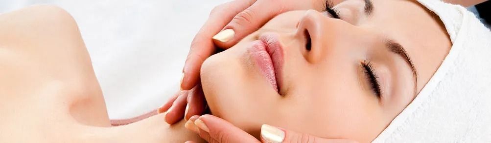 Una mujer está recibiendo un masaje facial en un spa.
