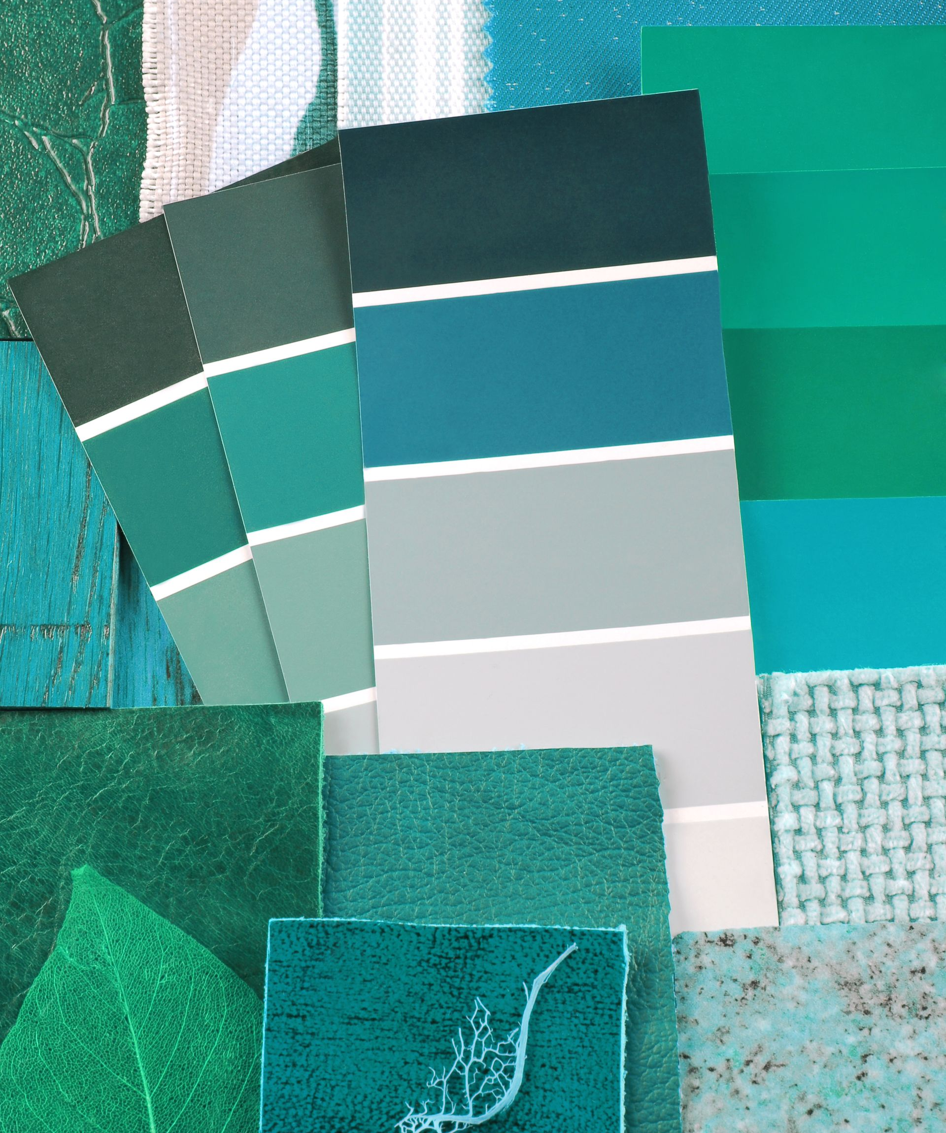 Échantillons de couleurs dans les tons turquoise, bleu-vert et gris, avec des échantillons de tissus texturés.