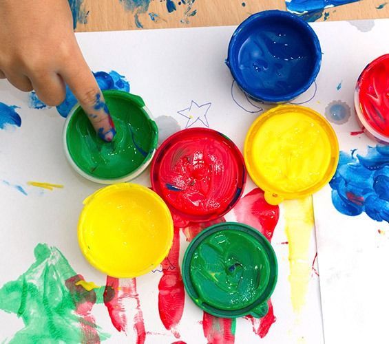 El dedo de un niño está atrapado en un recipiente con pintura.