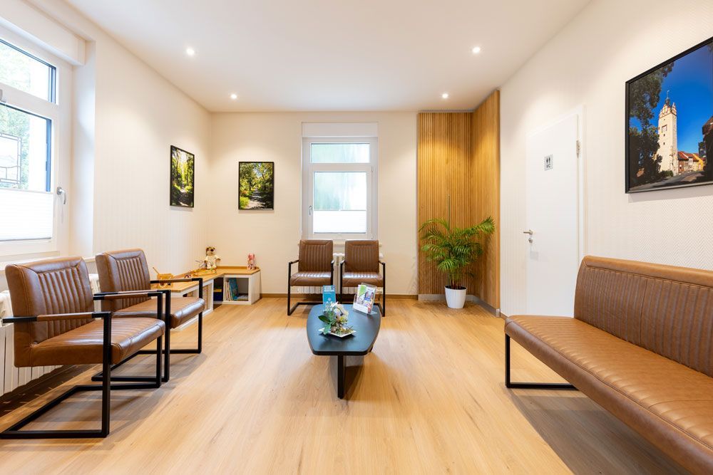 Ein Wartezimmer mit Stühlen und einem Tisch.