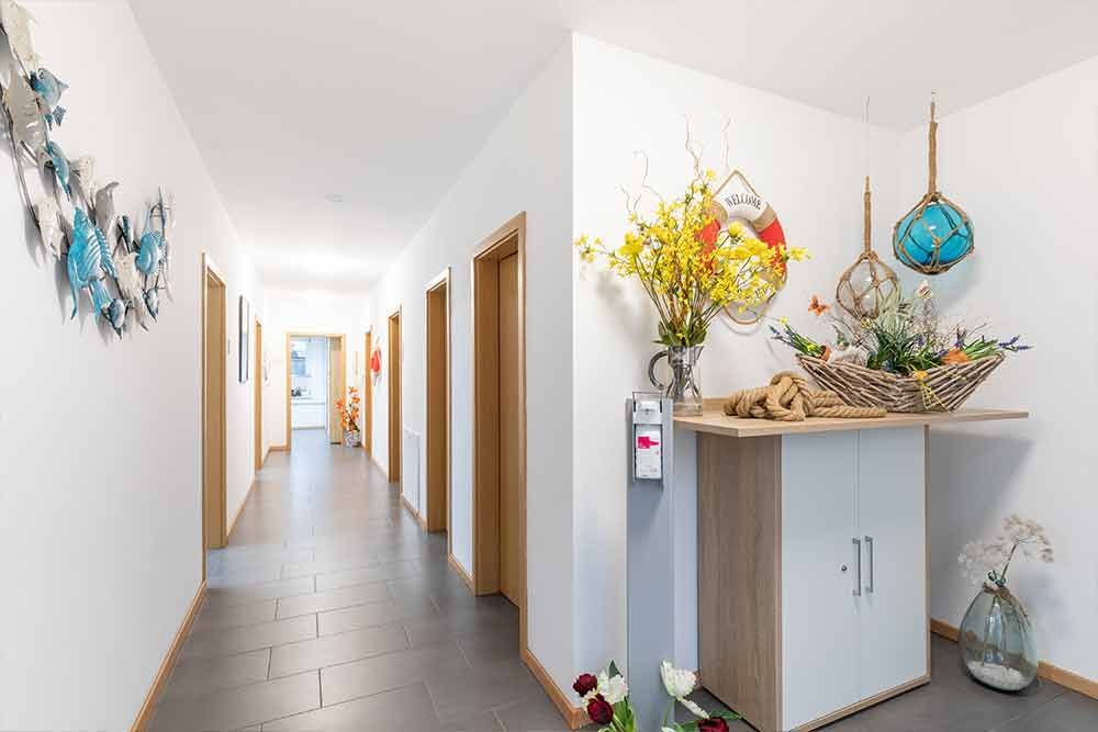 Ein langer Flur mit einem Tisch und Blumen darauf.