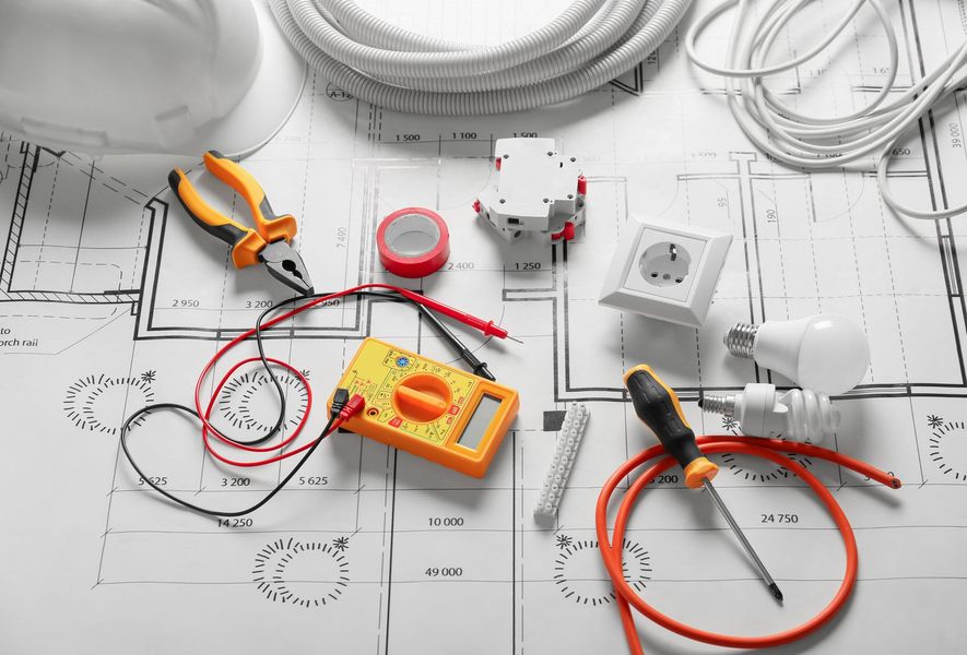 Outils et composants électriques figurant sur un plan, y compris le câblage, le multimètre et la prise de courant.