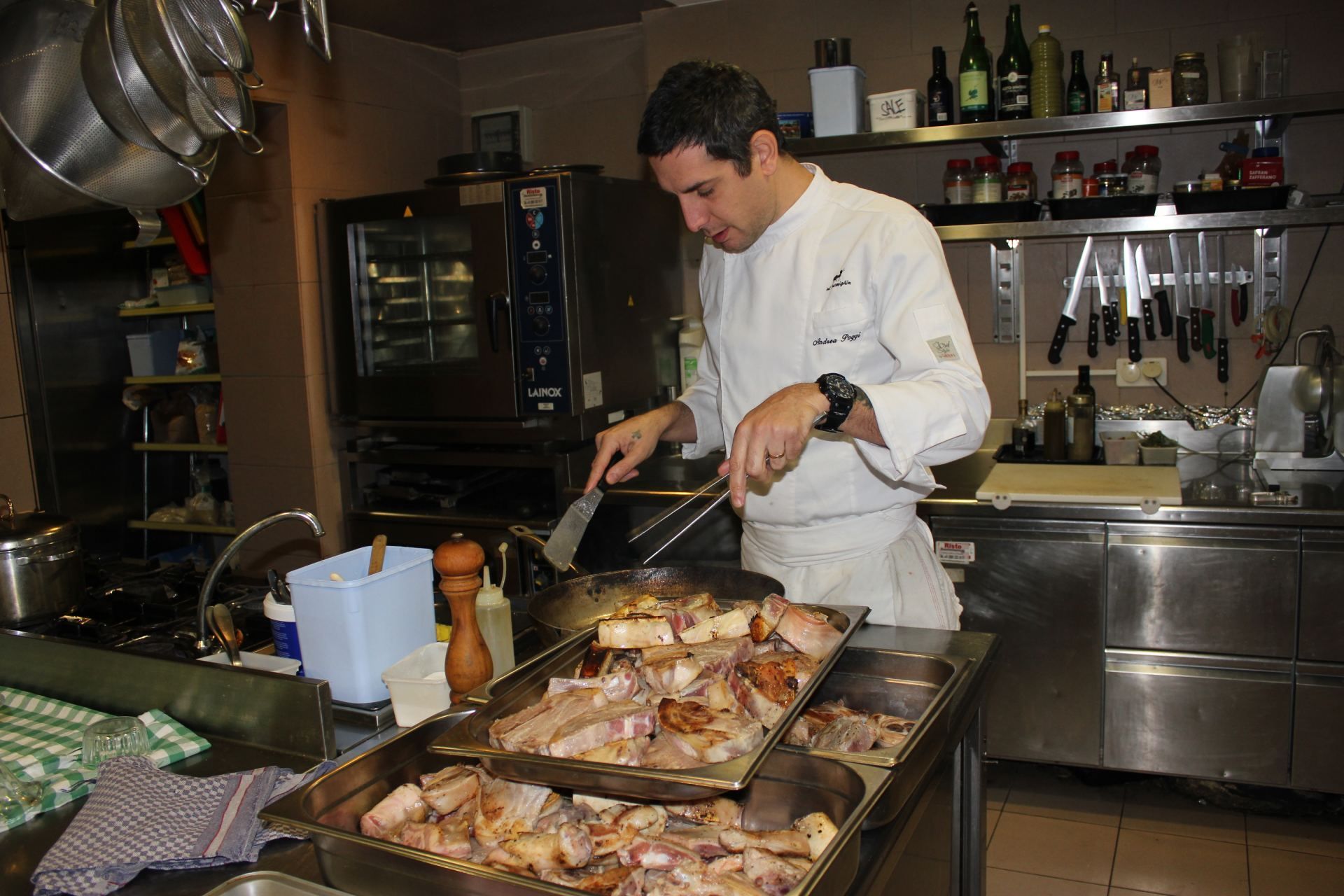 Un uomo in uniforme da cuoco sta preparando il cibo in cucina
