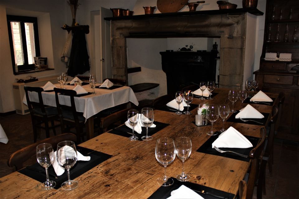 Un lungo tavolo di legno con bicchieri da vino e tovaglioli sopra