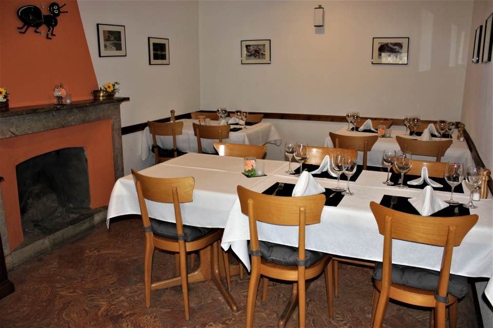 Una sala da pranzo con tavoli, sedie e un camino