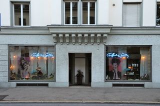 Coiffure Gody - Blick auf den Coiffeursalon von der Strasse aus, weisse Gebäudefassade mit Schaufenstern