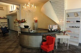 Coiffure Gody - Blick auf die Rezeption des Coiffeursalons, roter Stuhl, Stahltheke